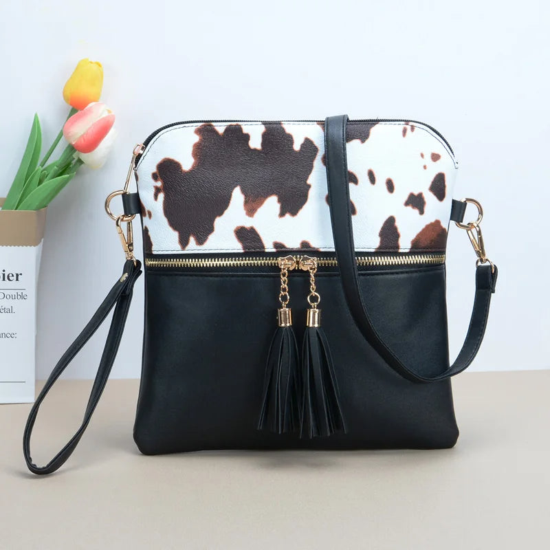 Trinity - koeienprint crossbody tas met kwastjes